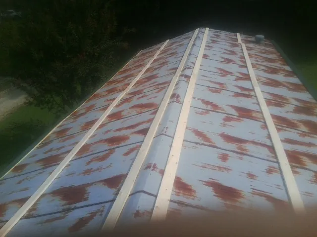 Rusted metal roof panels with new wood purlins before replacement — Storm Damage Roof Repair in Bunnlevel by Roofing Brothers