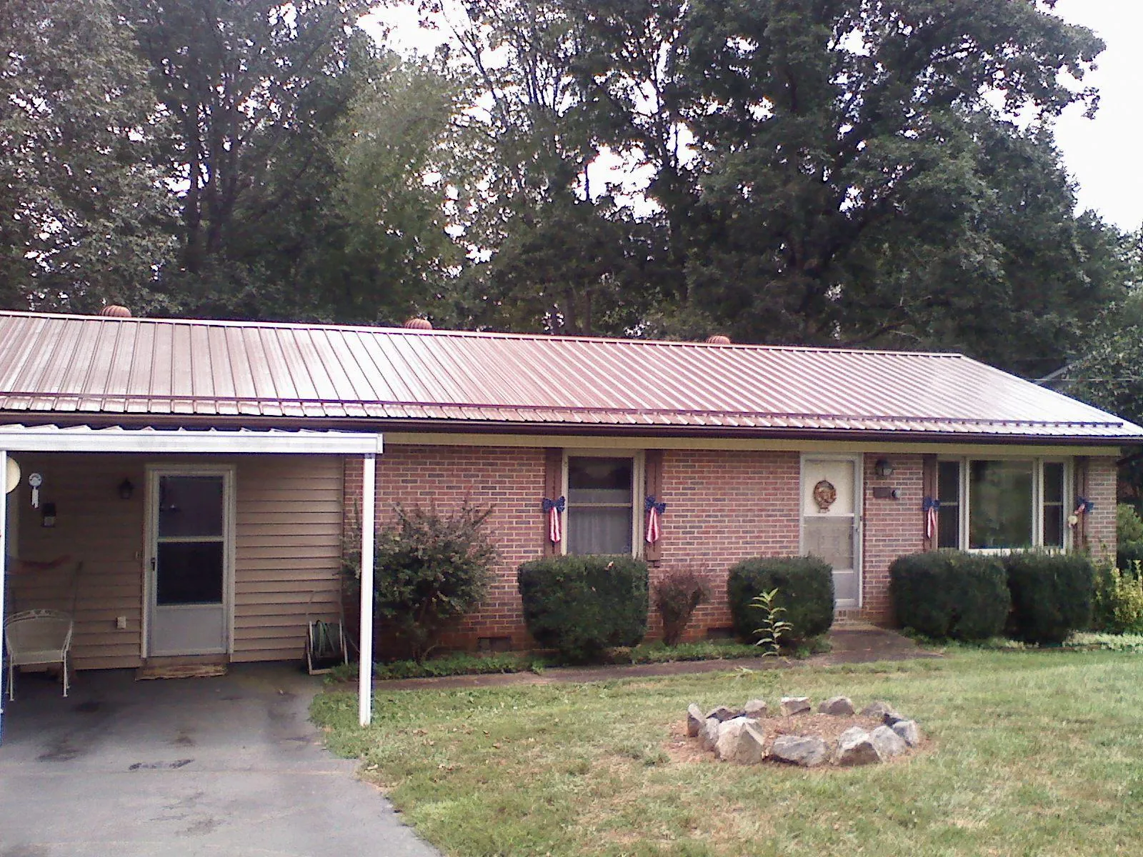 Bronze metal roof and carport on a brick ranch home — Roof Repair work by our crew in Bunnlevel